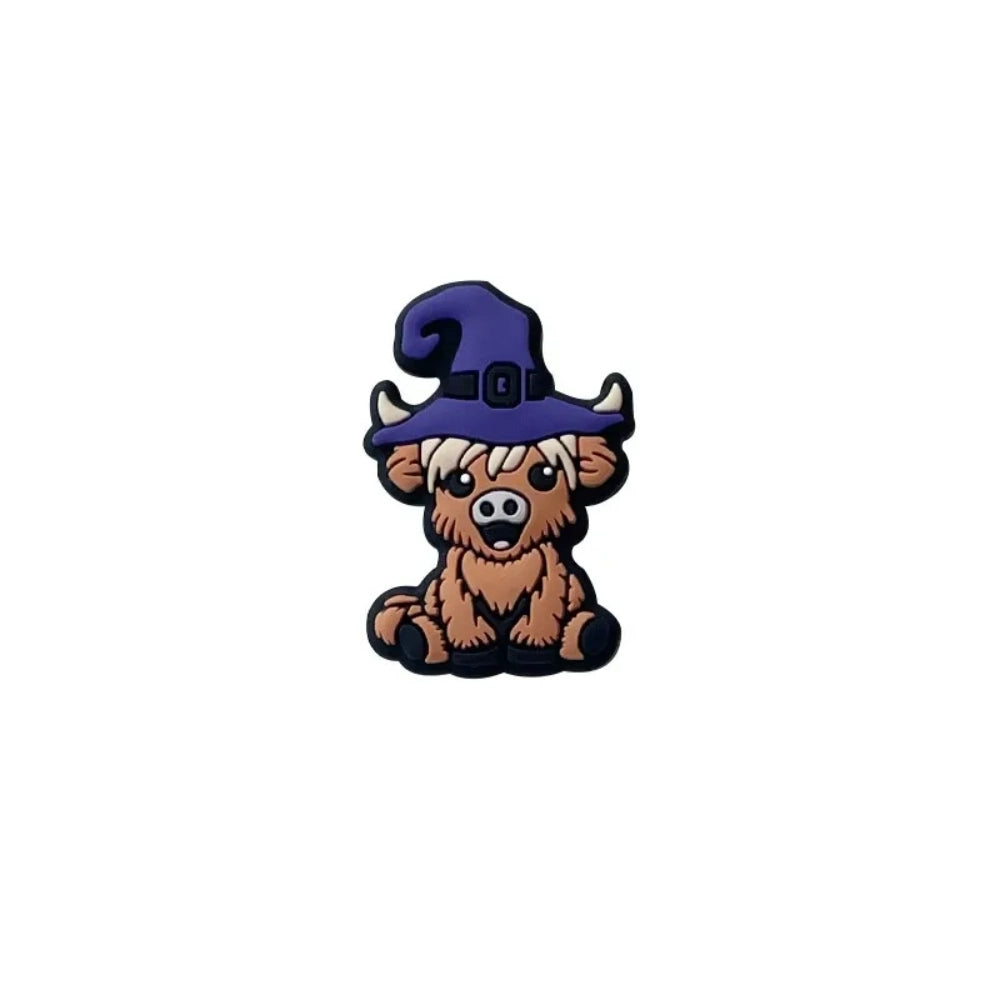 Four 3D silicone focal beads shaped like cartoon highland cows wearing witch hats in pink, yellow-green, purple, and dark purple, displayed on a white tray with a beadable pen. - Purple