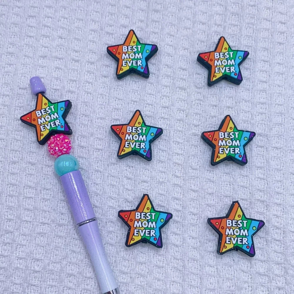 Silicone focal beads featuring Jesus Loves You round, Best Mom Ever star, and Live in the Sunshine heart designs displayed on beadable pens and scattered on a white plate, colorful DIY craft supplies from DIY Mini Planet. - 2