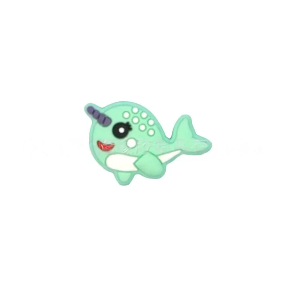Set of 5 kawaii narwhal silicone focal beads in teal, mint, pink, light blue, gray, and dark gray, displayed on a miniature white bench with blue background. - 4