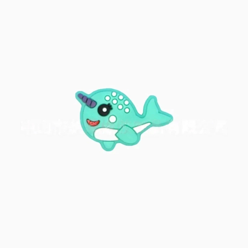 Set of 5 kawaii narwhal silicone focal beads in teal, mint, pink, light blue, gray, and dark gray, displayed on a miniature white bench with blue background. - 5