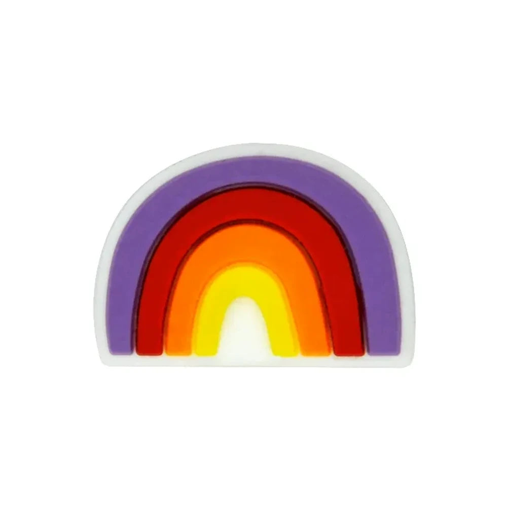 Five colorful silicone rainbow arch focal beads in various color combinations including blue-gray, multicolor, dark-mint, boho pink, and pink-teal, displayed on a wooden slice with pine cones on a star-patterned surface. - Purple