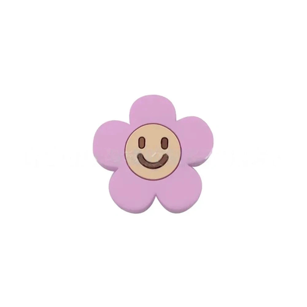 10 colorful smiley face daisy flower silicone focal beads in white, yellow, mustard, teal, sage, pink, light pink, lavender, purple, and hot pink on a tan background. - Light Purple