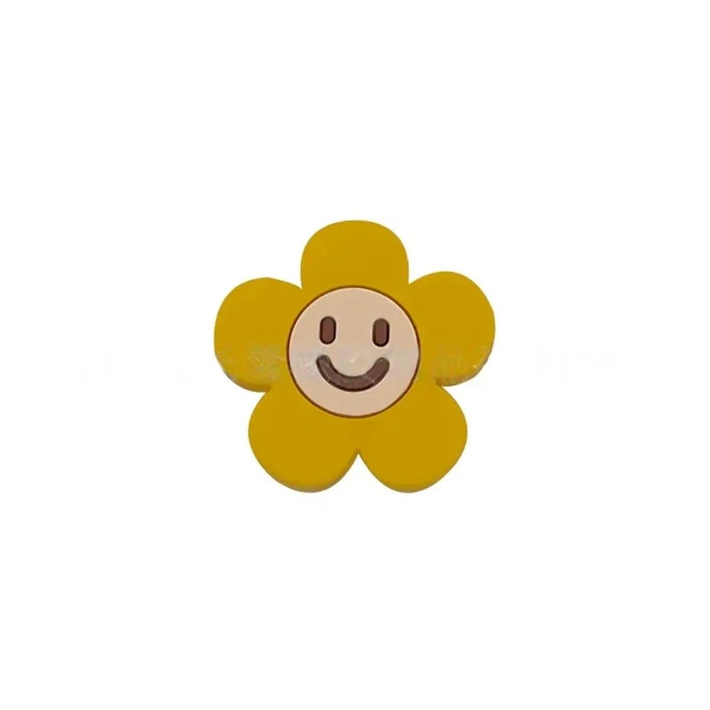 10 colorful smiley face daisy flower silicone focal beads in white, yellow, mustard, teal, sage, pink, light pink, lavender, purple, and hot pink on a tan background. - Mustard Yellow