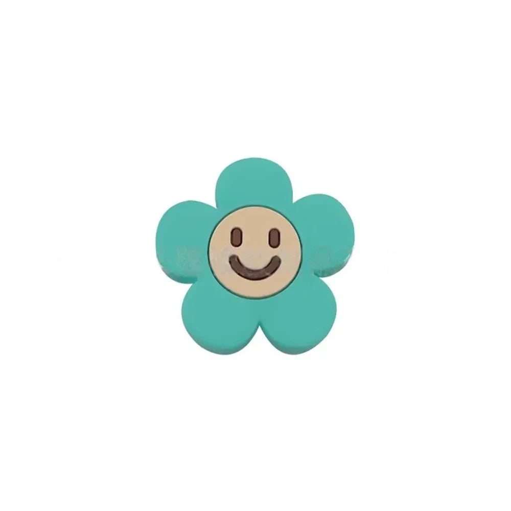 10 colorful smiley face daisy flower silicone focal beads in white, yellow, mustard, teal, sage, pink, light pink, lavender, purple, and hot pink on a tan background. - Turquoise