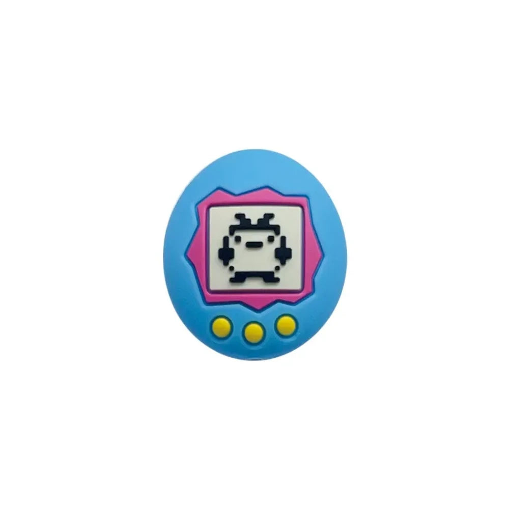 Assorted Tamagotchi silicone focal beads in pink and blue colorways displayed alongside four completed beadable pens on a pink background, showing pixel pet virtual pet screen design detail. - Blue