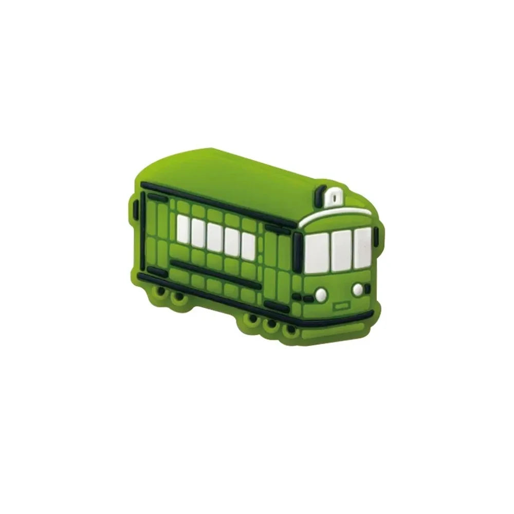 Four colorful silicone tram streetcar focal beads in blue, yellow, red, and green displayed on a pink background with miniature versions shown in a white dish above. - Green