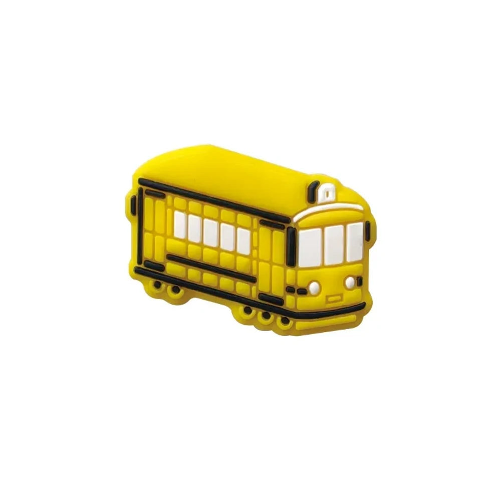 Four colorful silicone tram streetcar focal beads in blue, yellow, red, and green displayed on a pink background with miniature versions shown in a white dish above. - Yellow