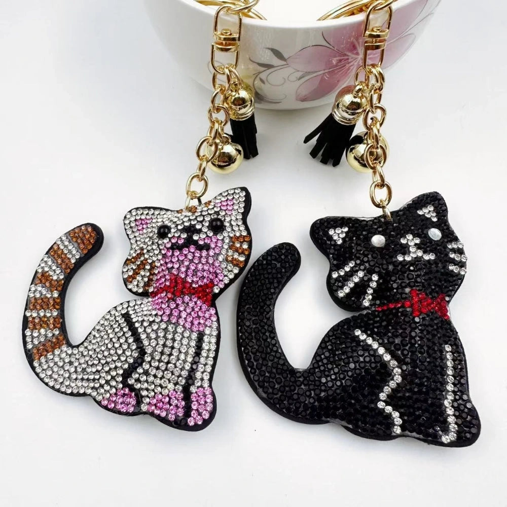 Black and white cat-shaped pave rhinestone fancy bead charms with gold-tone chain, tassels, and bow details.