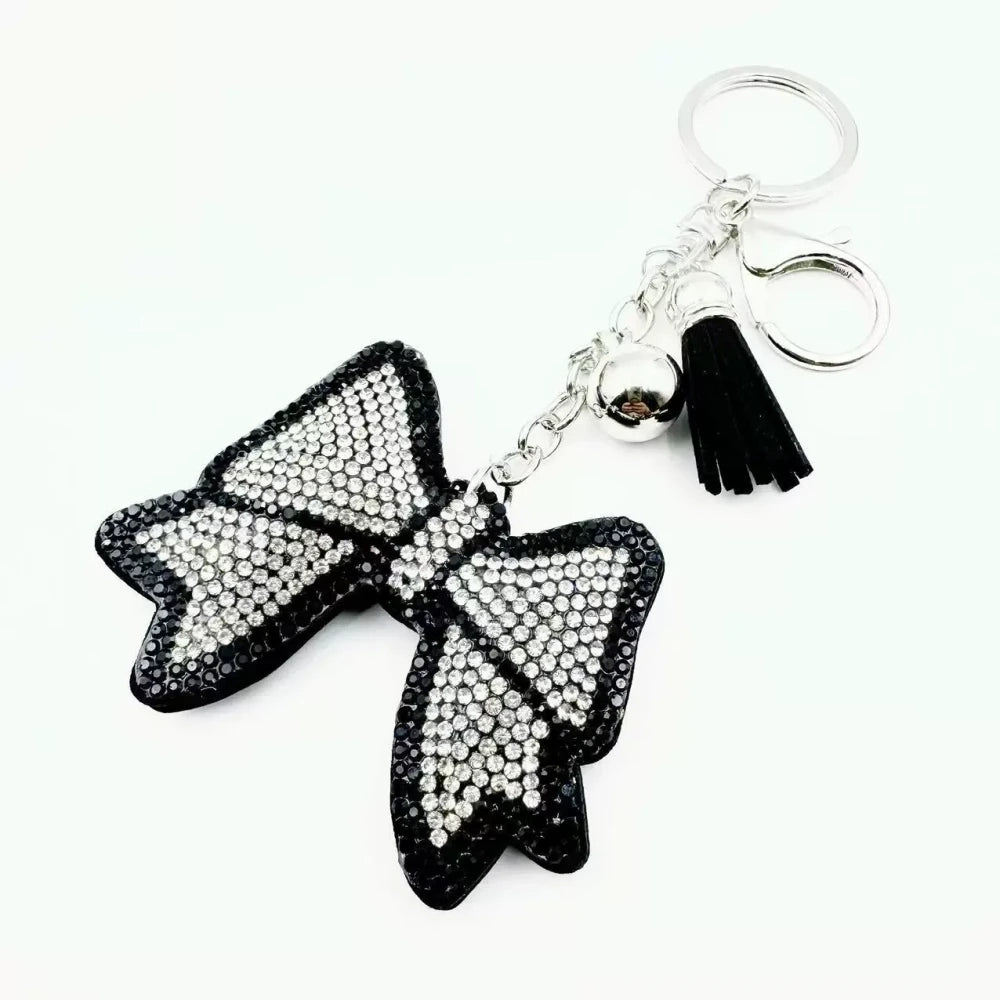 Pink and black bling bow rhinestone fancy beads with tassels, bell charms, and silver keychain hardware - White