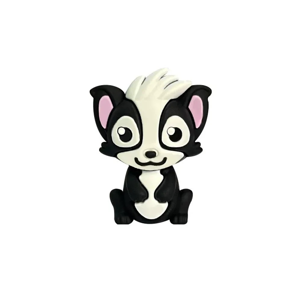 Three cute cartoon skunk silicone focal beads in gray, dark gray, and black colorways displayed on beadable pens with decorative silicone beads on a woven mat background. - Black