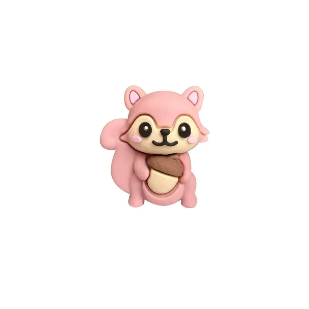 Five cute 3D squirrel silicone focal beads holding acorns in gray, pink, brown, dark gray, and red-brown colors displayed on decorative beadable pens against a pink background. - Pink
