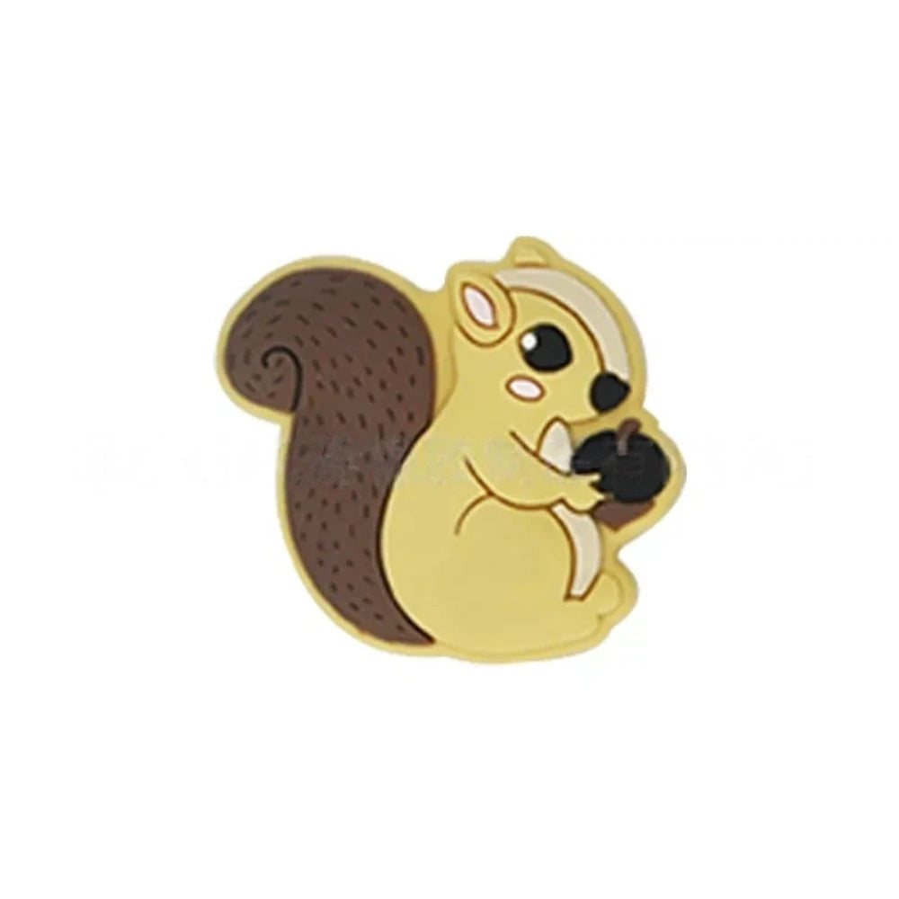 Six cute cartoon squirrel silicone focal beads holding acorns in brown, yellow, grey, dark pink, light pink, and blue colors arranged on a miniature white bench. - Brown