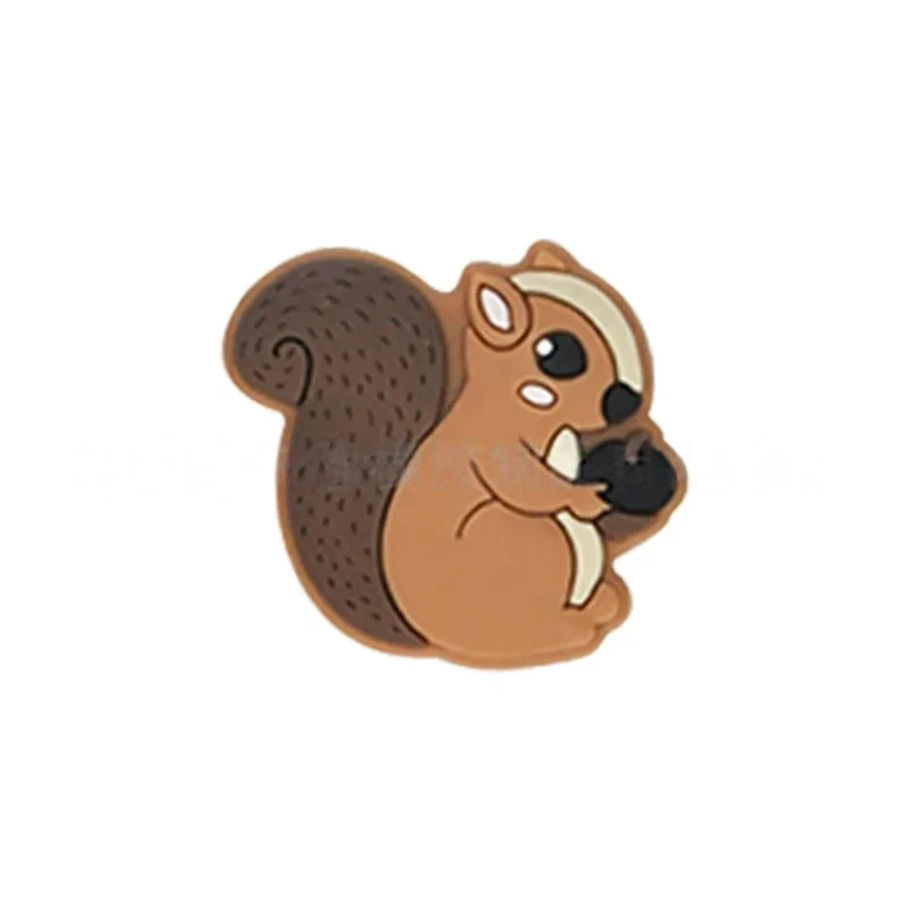 Six cute cartoon squirrel silicone focal beads holding acorns in brown, yellow, grey, dark pink, light pink, and blue colors arranged on a miniature white bench. - Camel