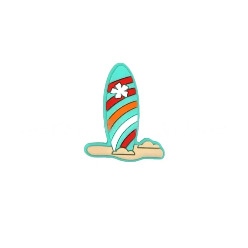 Colorful striped surfboard silicone focal beads in blue and white with flower detail, displayed in a white shell-shaped dish on a light blue background. - Turquoise