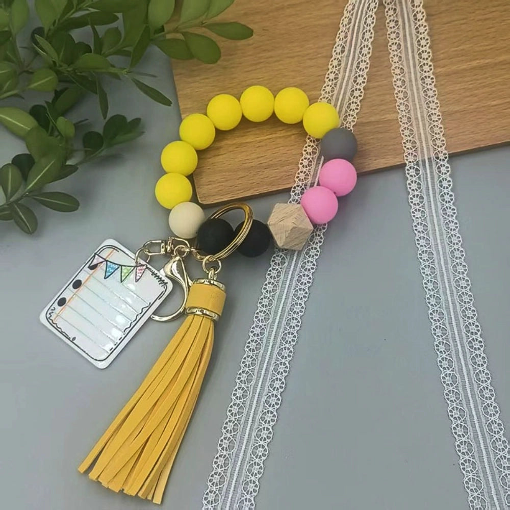 Colorful TEACH letter printed silicone bead bracelet keychains with pencil charms and tassel accents in mint, pink, rainbow, and yellow color combinations - 1