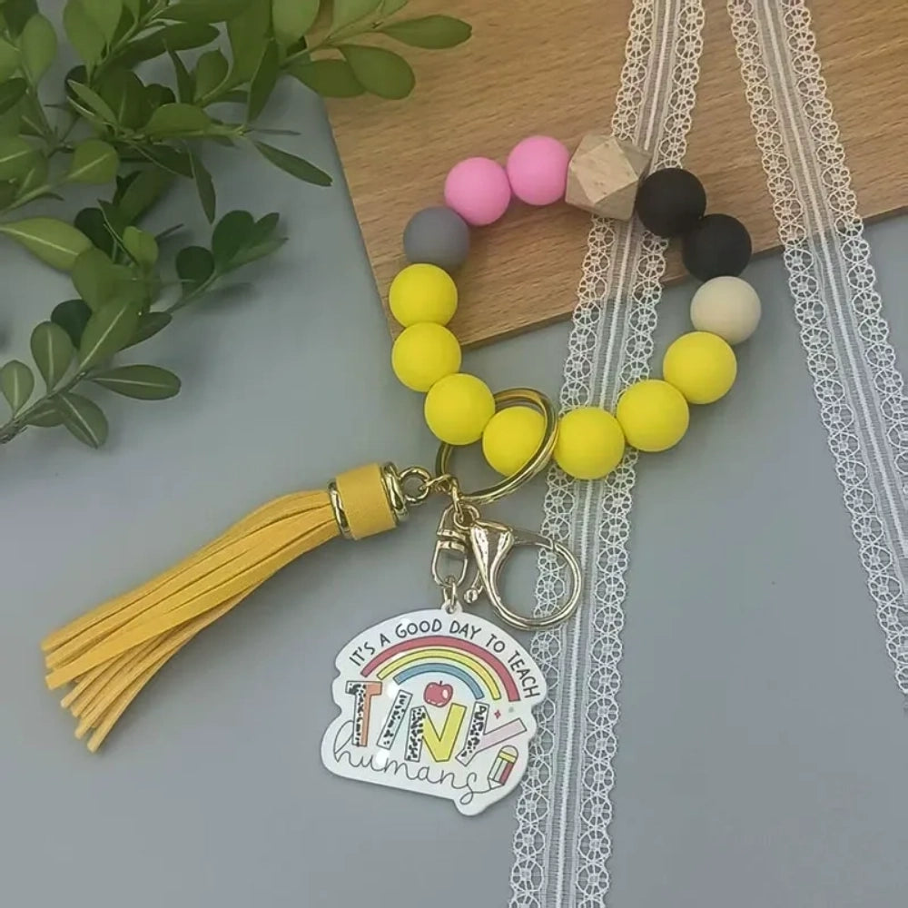 Colorful TEACH letter printed silicone bead bracelet keychains with pencil charms and tassel accents in mint, pink, rainbow, and yellow color combinations - 2