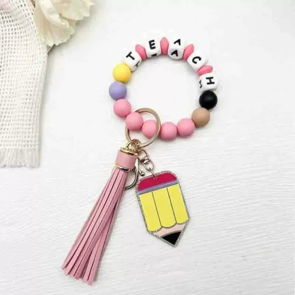 Colorful TEACH letter printed silicone bead bracelet keychains with pencil charms and tassel accents in mint, pink, rainbow, and yellow color combinations - 3