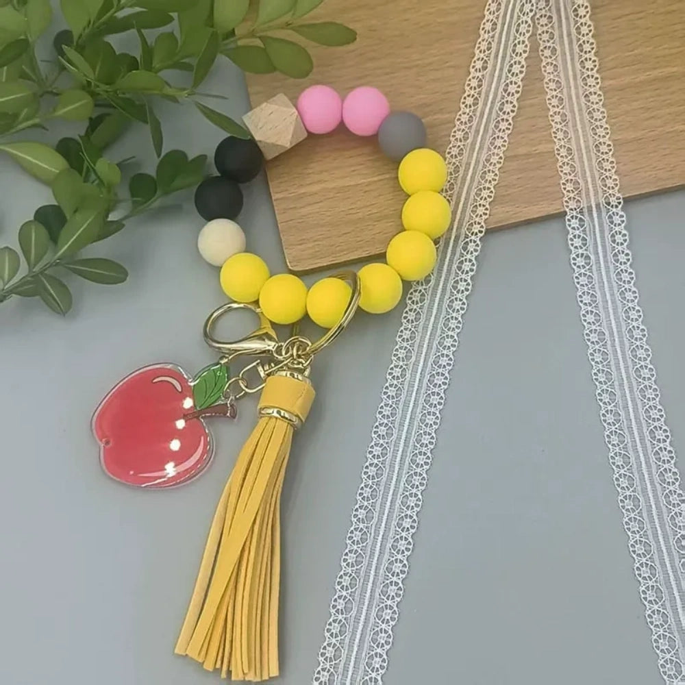 Colorful TEACH letter printed silicone bead bracelet keychains with pencil charms and tassel accents in mint, pink, rainbow, and yellow color combinations - 4
