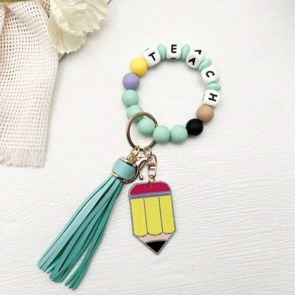 Colorful TEACH letter printed silicone bead bracelet keychains with pencil charms and tassel accents in mint, pink, rainbow, and yellow color combinations - 8