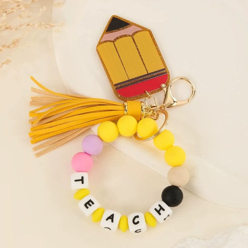 Colorful TEACH letter printed silicone beads on beaded bracelet keychains with tassels and teacher-themed charms including pencil, apple, rainbow, and Be Kind pendants. - C