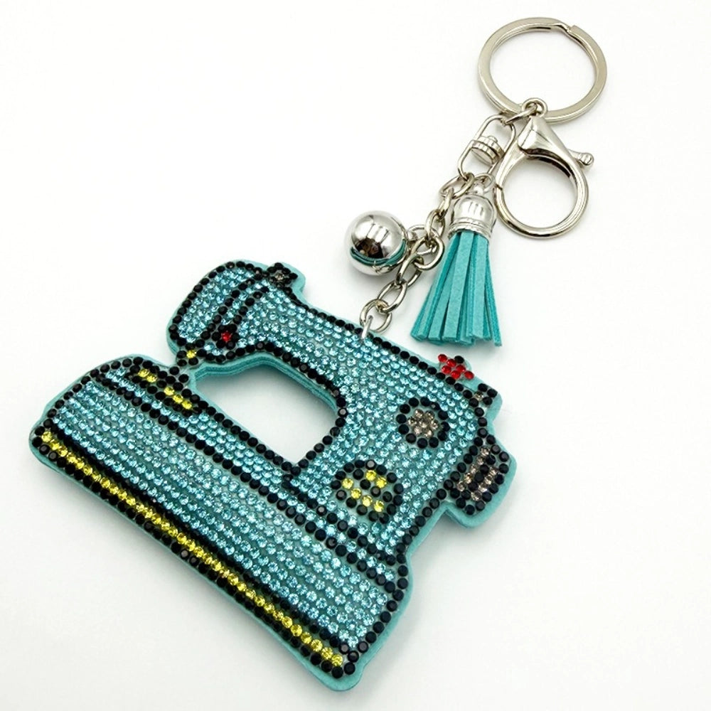 Teal rhinestone sewing machine keychain charm with silver lobster clasp, mini tassel, and ball accent on white background