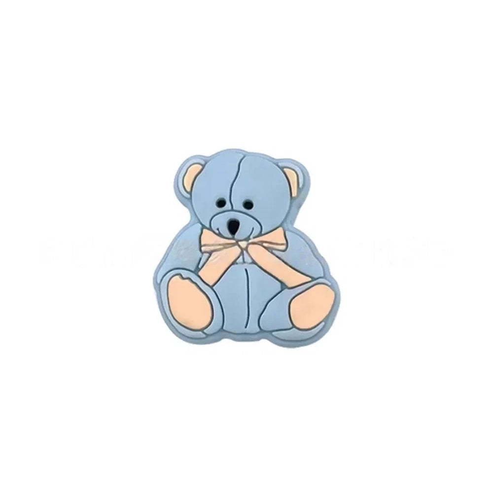 Six teddy bear silicone focal beads in white, tan, pink, mint, blue, and gray, each with a bow tie accent, displayed on a white background for DIY craft projects. - Blue