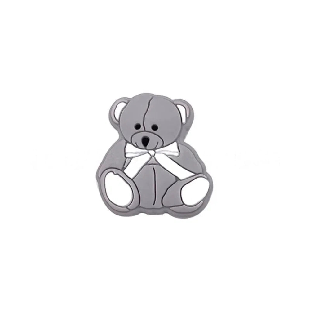 Six teddy bear silicone focal beads in white, tan, pink, mint, blue, and gray, each with a bow tie accent, displayed on a white background for DIY craft projects. - Gray