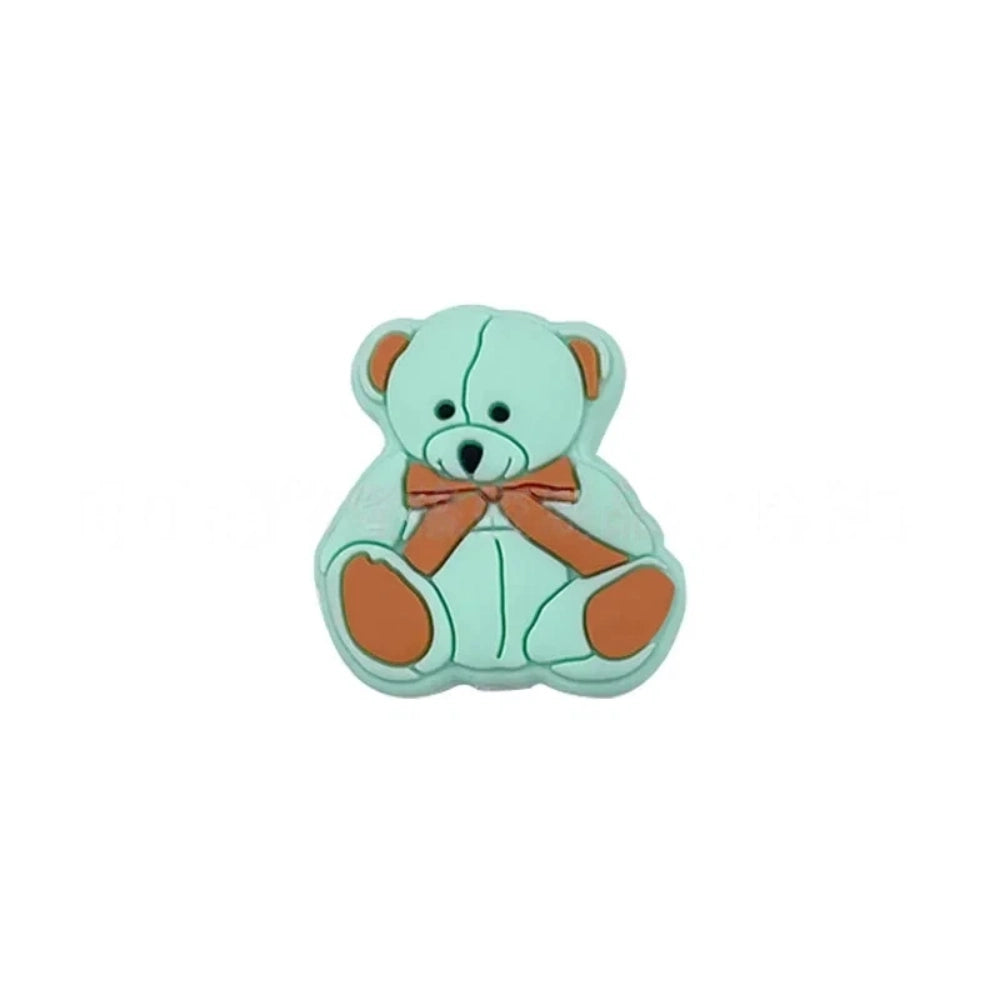 Six teddy bear silicone focal beads in white, tan, pink, mint, blue, and gray, each with a bow tie accent, displayed on a white background for DIY craft projects. - Green