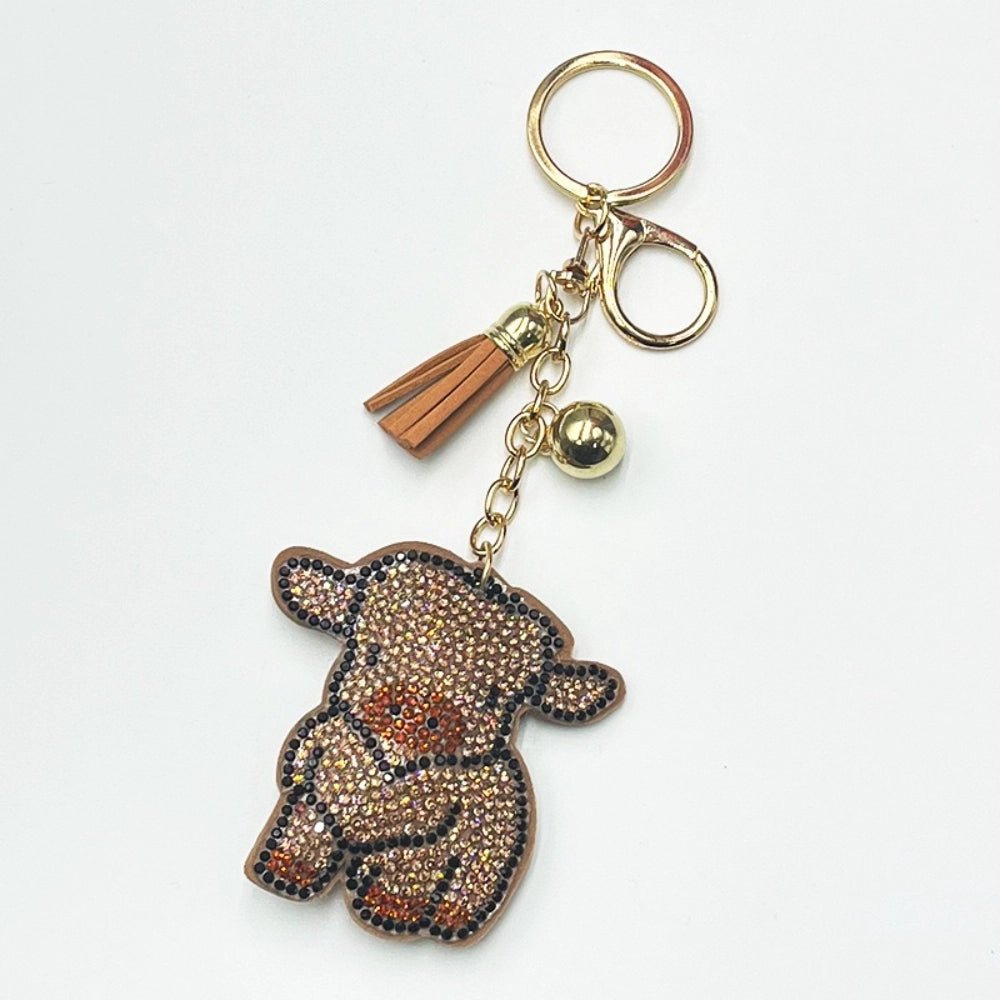 Gold tone keychain with brown tassel and sparkly rhinestone teddy bear charm on a white background
