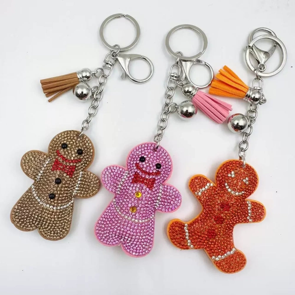 Three rhinestone gingerbread figure keychain charms in brown, pink, and orange with tassels and silver clasp rings - Random Mixed